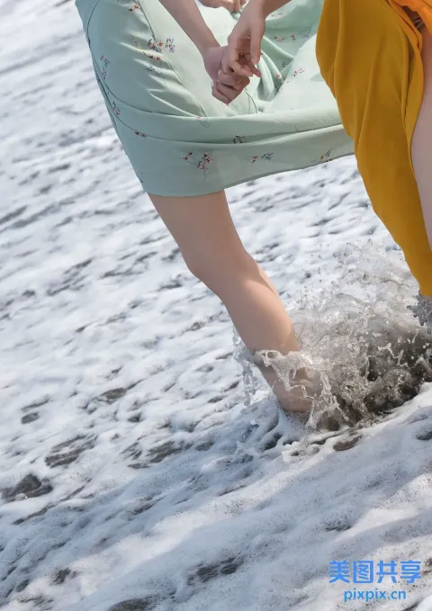有两个女人手牵手在水中行走