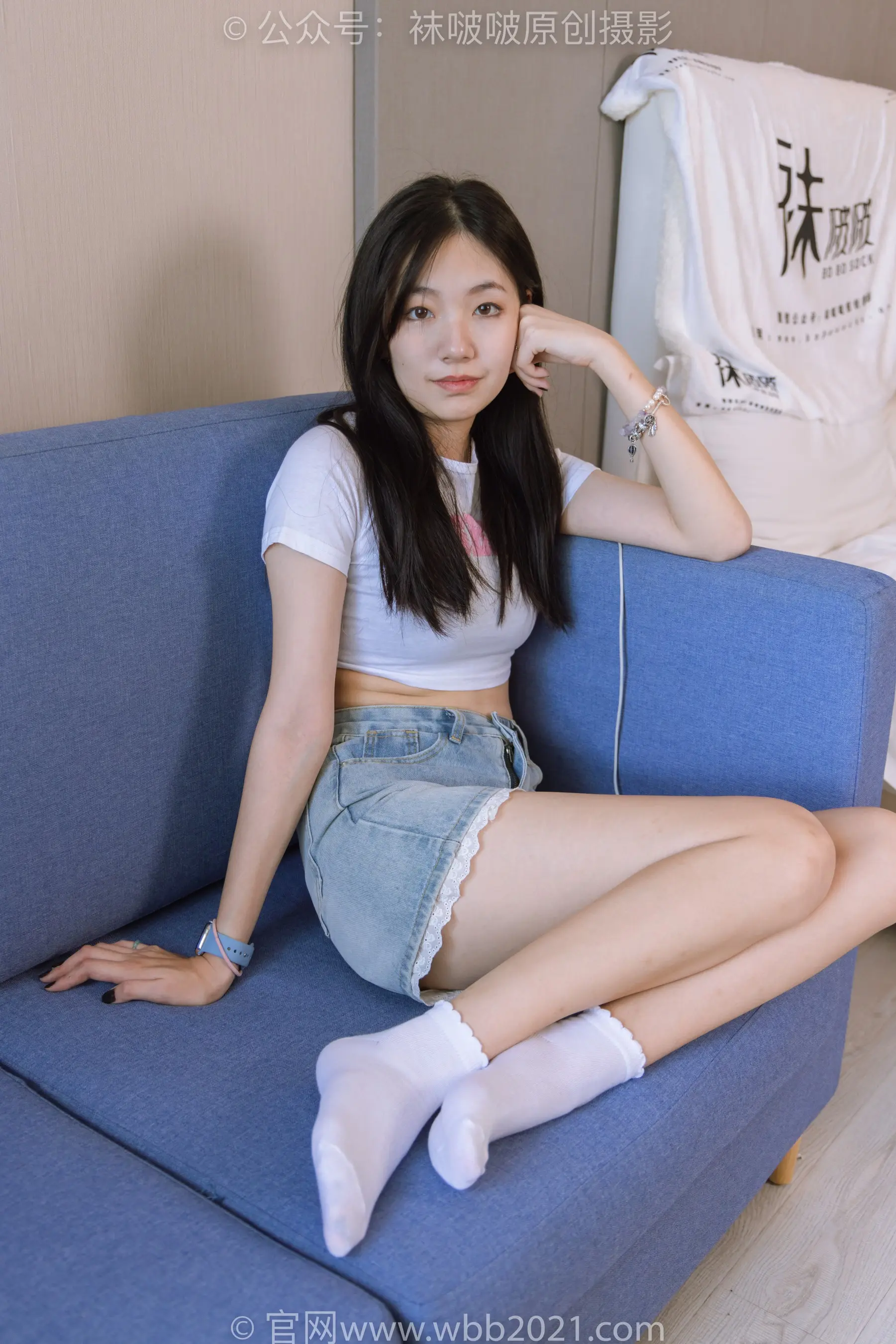 阿拉夫德女人坐在蓝色沙发上，双腿交叉