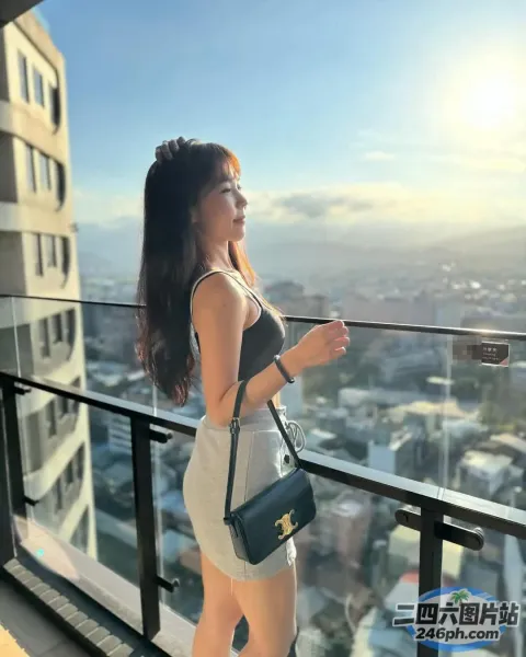 一个女人站在阳台上，手里拿着钱包，眺望着城市