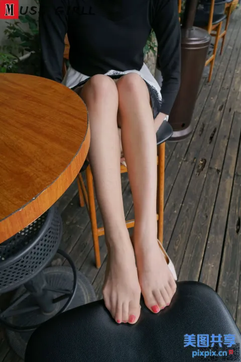 有个女人坐在椅子上，脚放在桌子上