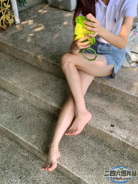 台阶上坐着一个女人，手里拿着一串香蕉
