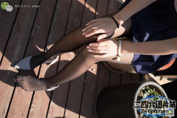 有一个女人坐在木甲板上，双腿交叉