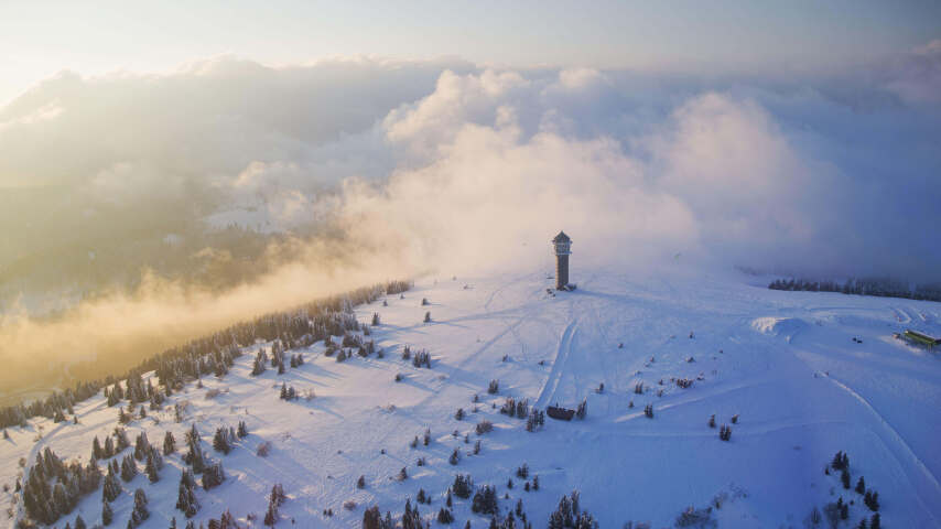 雪山上的滑雪者，远处有一座塔