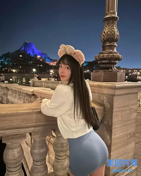 一名身穿裙子和白衬衫的女子在桥上摆姿势