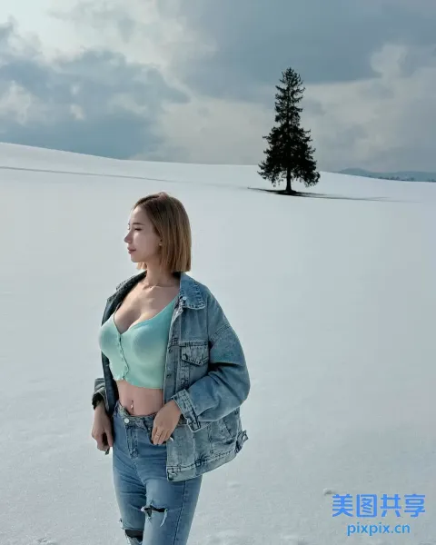 阿拉费德女人站在雪地里，背景是一棵树