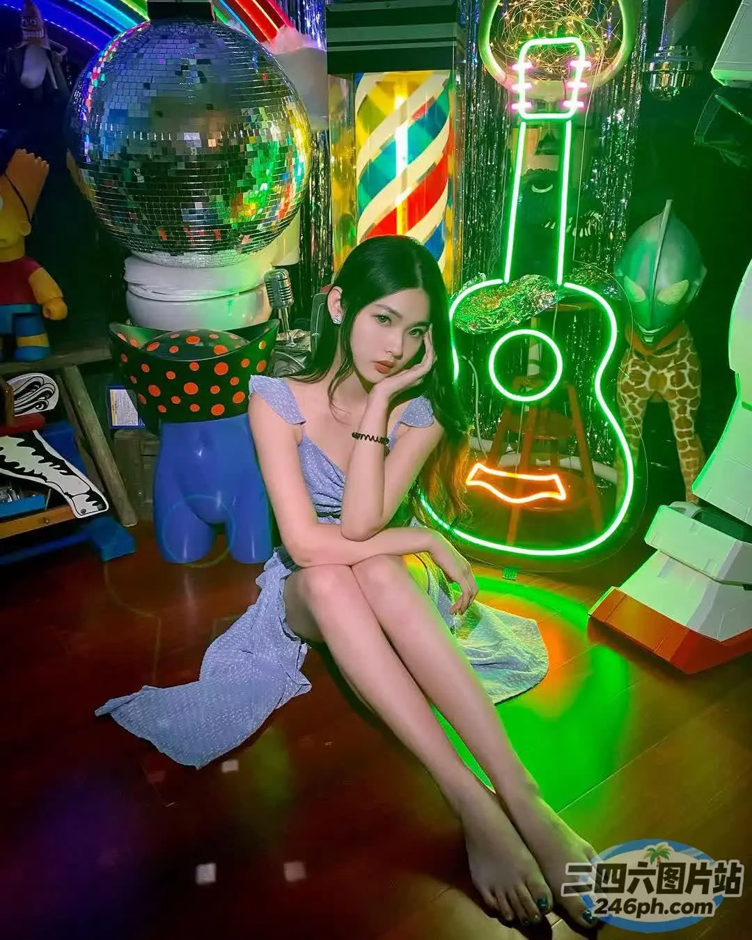 坐在霓虹灯招牌前地板上的 arafed 女人