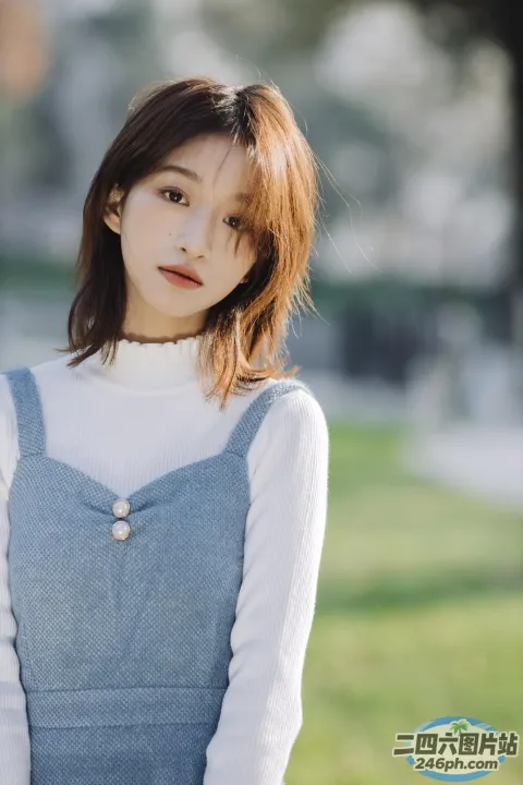 一个穿着蓝色连衣裙的女人站在公园里