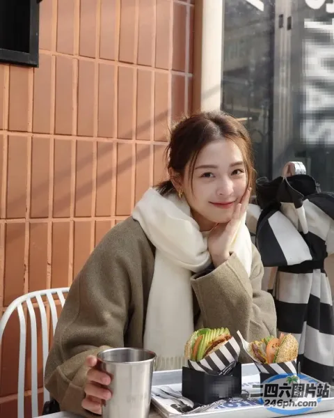 Araffe 坐在一张桌子旁，手里拿着一个三明治和一杯饮料