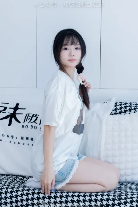 一个女人坐在床上拿着枕头的特写