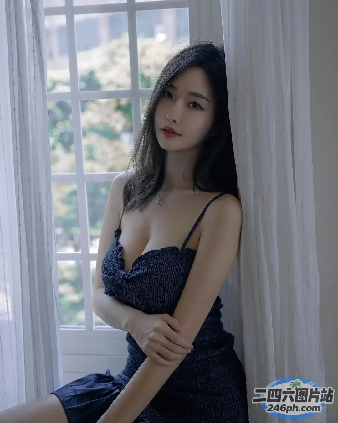 一个穿着蓝色连衣裙的女人坐在窗台上