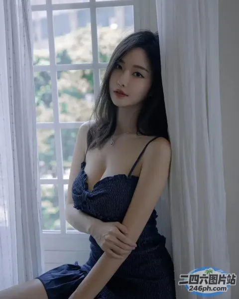 一个穿着蓝色连衣裙的女人坐在窗台上