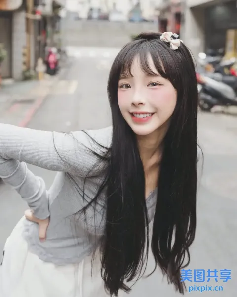 一位黑发长发女子站在街上的特写
