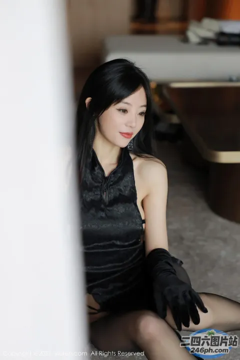 地板上坐着一个戴着黑色手套的女人