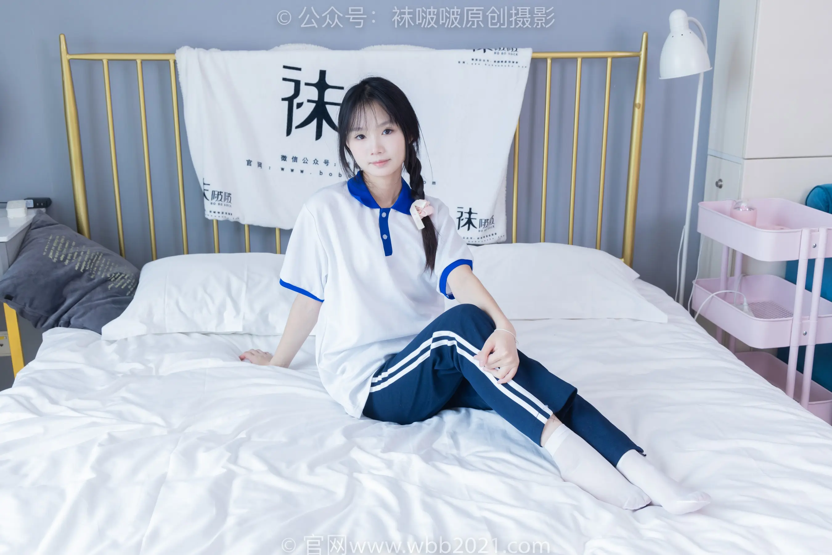 床上坐着一个穿着白衬衫的女人