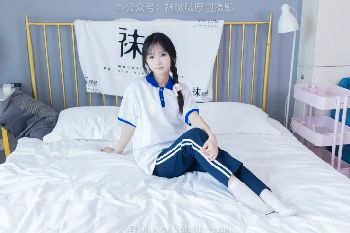 床上坐着一个穿着白衬衫的女人