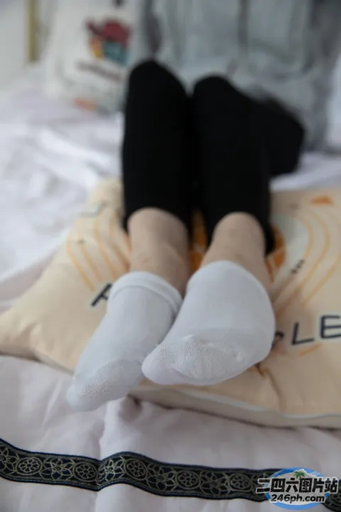 有人坐在床上，双脚放在枕头上