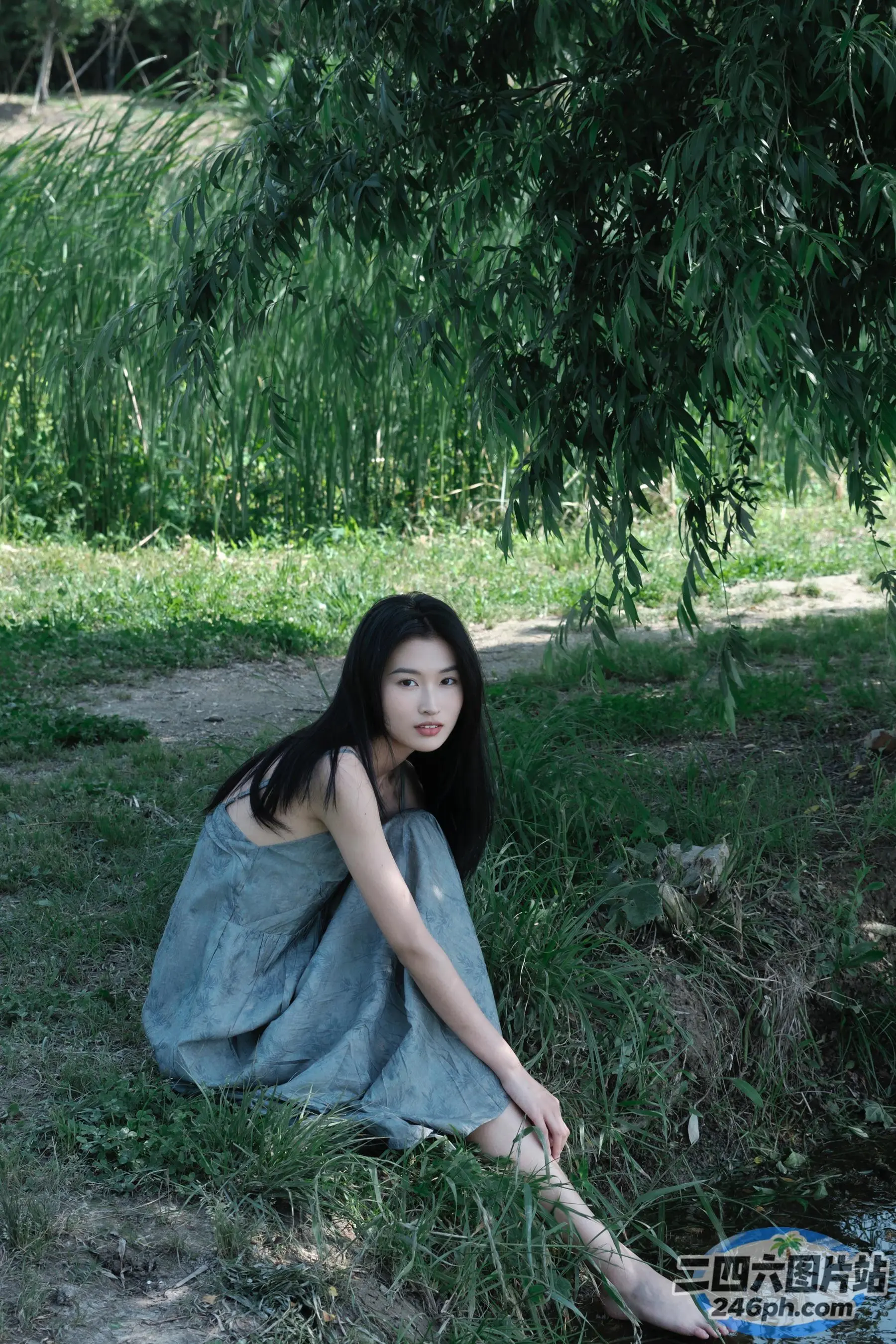 穿着蓝色连衣裙坐在地上的阿拉菲德女人