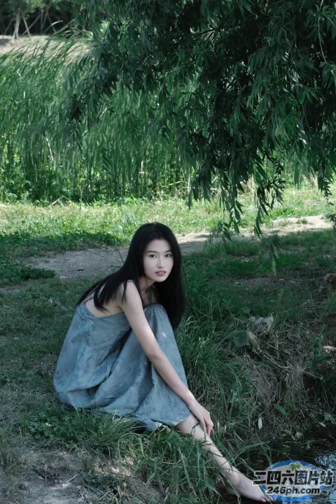 穿着蓝色连衣裙坐在地上的阿拉菲德女人