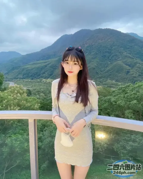 一个女人站在阳台上，背景是一座山
