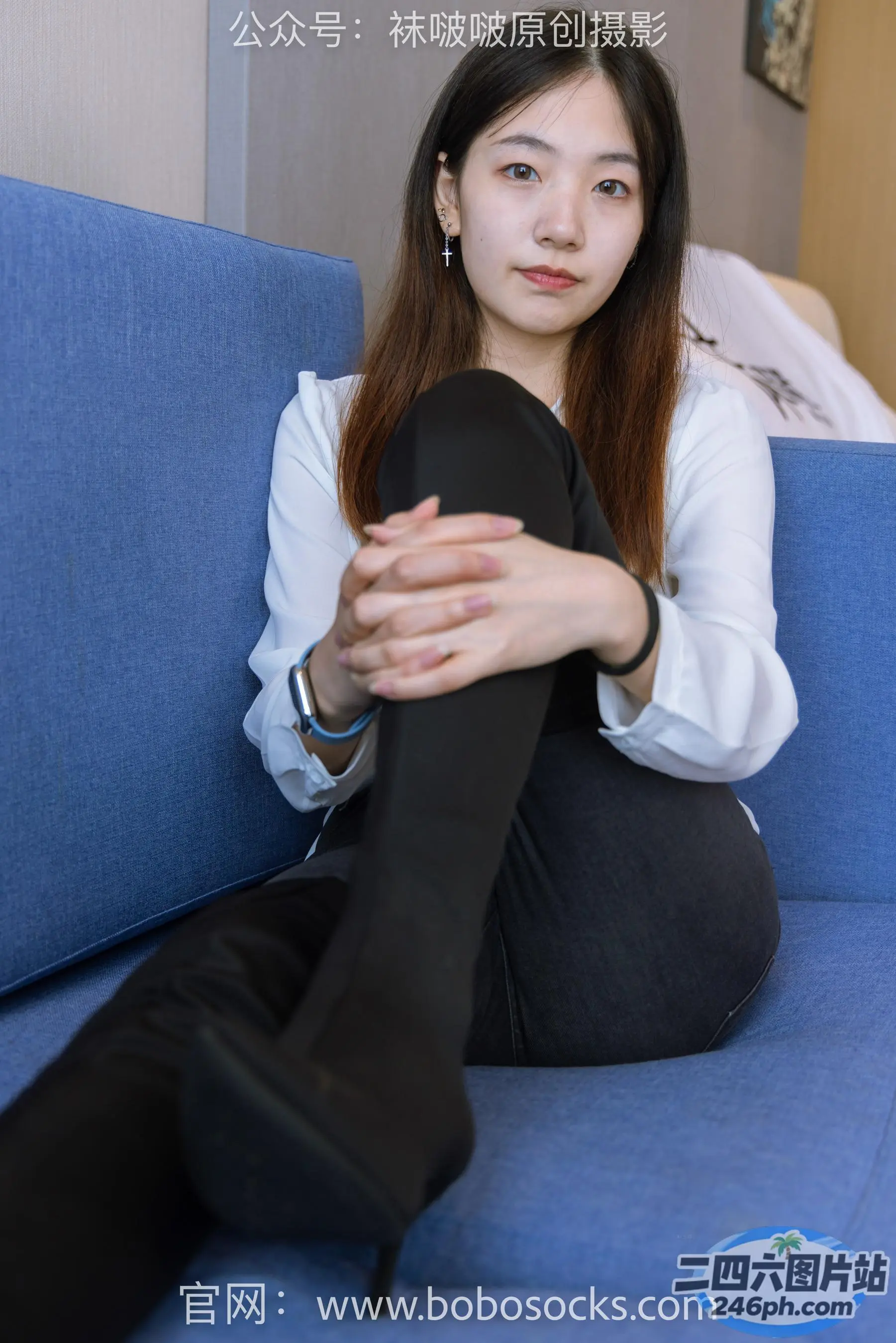 阿拉夫德女人坐在蓝色沙发上，双腿交叉