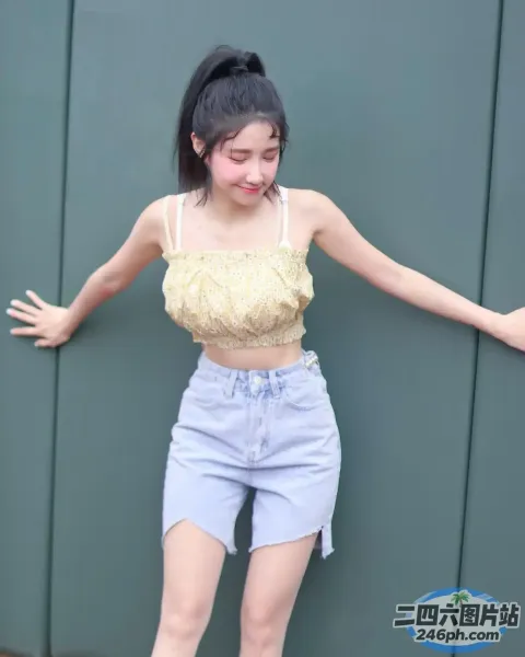 身穿黄色上衣和蓝色短裤的 Araffed 亚洲女子合影留念