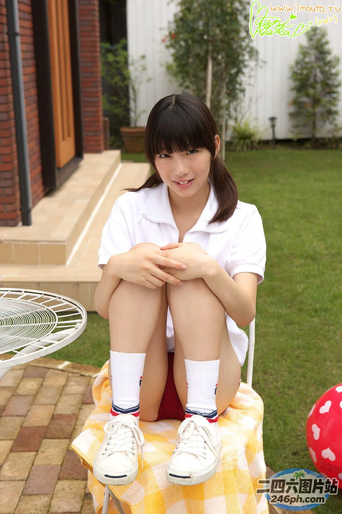坐在院子里椅子上的 arafed 亚洲妇女