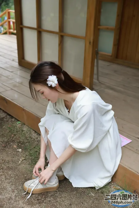 一名身穿白色连衣裙的女子将鞋子绑在地上