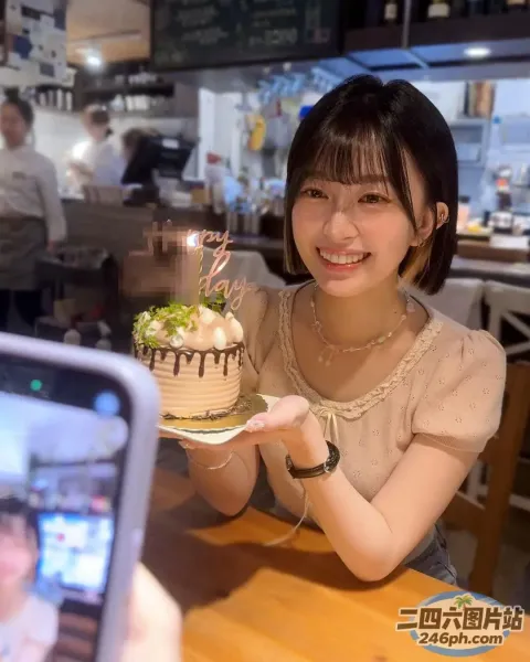 女子拿着一个点着蜡烛的蛋糕拍照