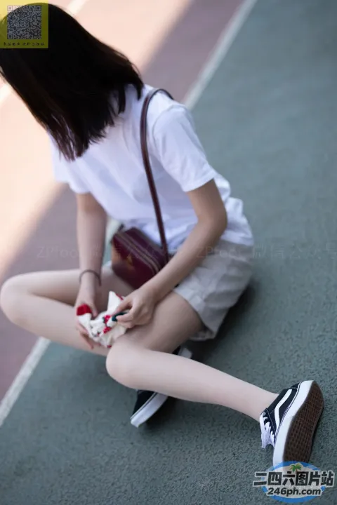 拿着网球拍坐在地上的阿拉菲德女人