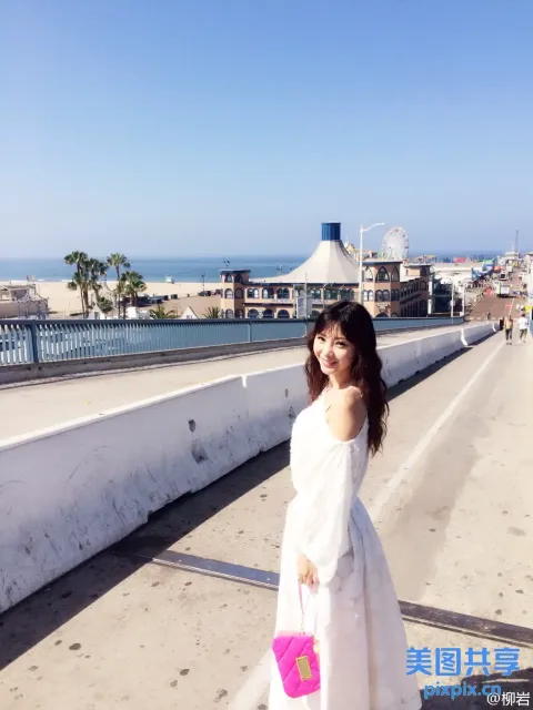 身穿白色连衣裙的阿拉夫女人站在桥上，手里拿着粉红色的钱包
