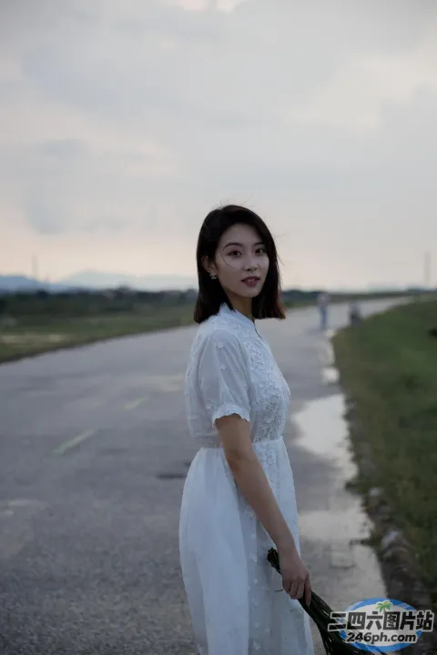 路边站着一个女人，手里拿着一束花