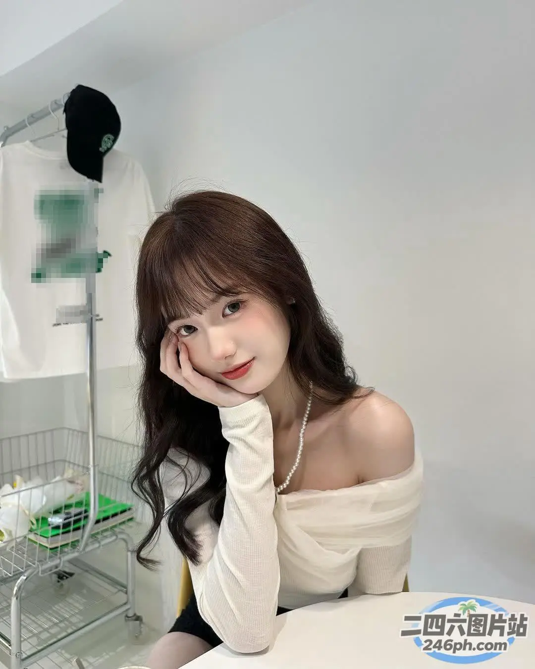 一位女士坐在一张桌子旁，手里拿着一条白毛巾和一条白毛巾