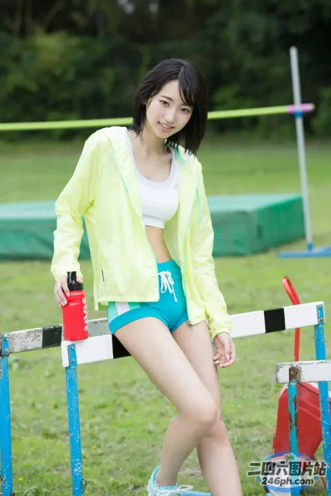 身穿黄色夹克的亚洲女子倚靠在栅栏上