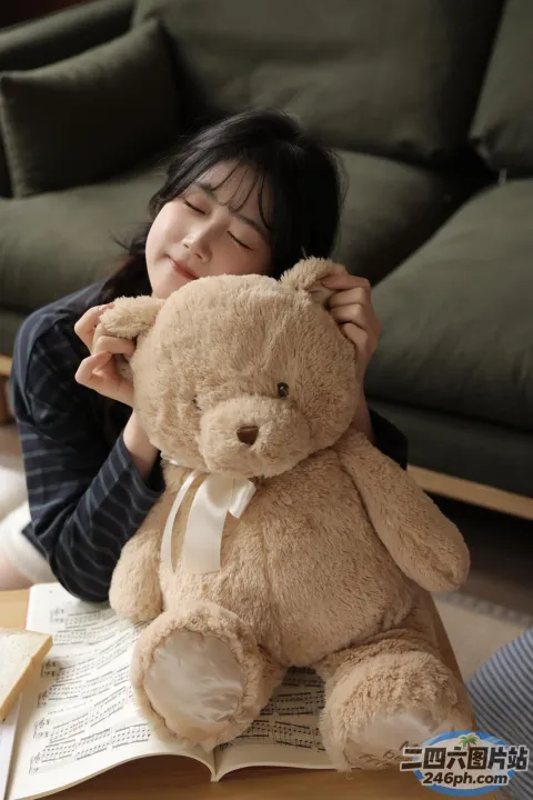 阿拉菲德女孩和一只泰迪熊躺在桌子上