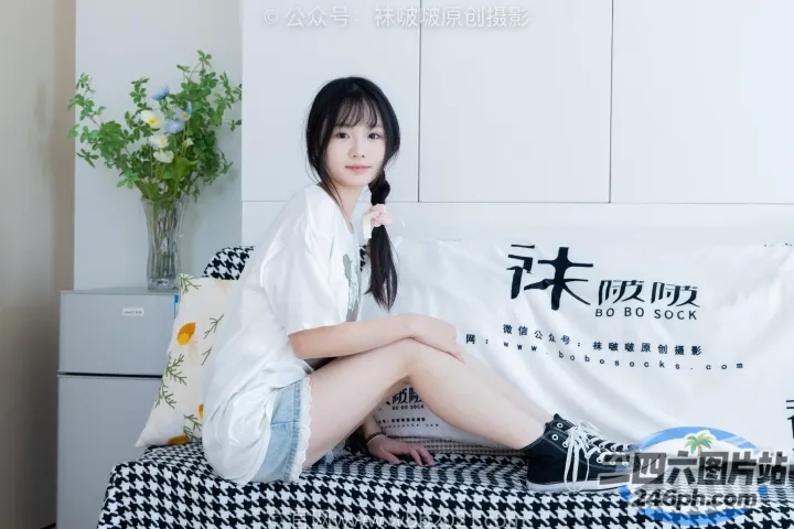 有一个女人坐在床上，上面盖着一条白色的毯子