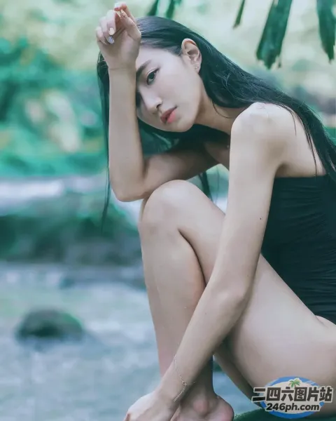 身穿黑色泳衣坐在岩石上的阿拉夫德亚洲女子