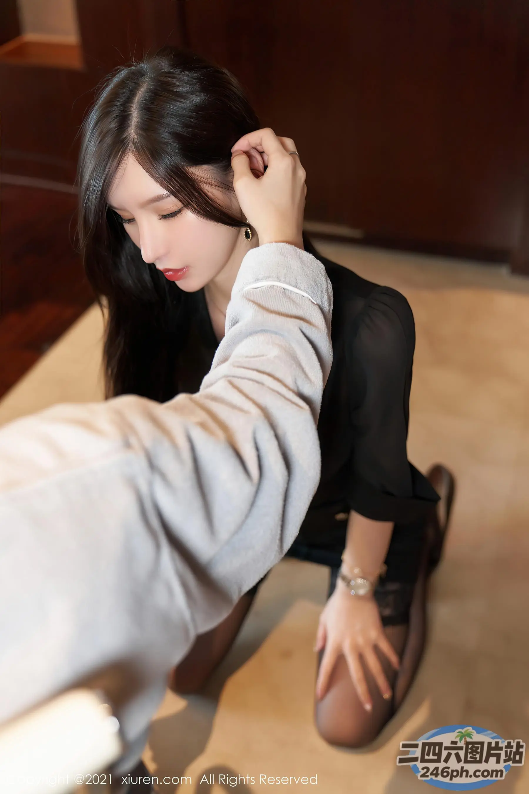 坐在地板上系男领带的 Araffe 女子