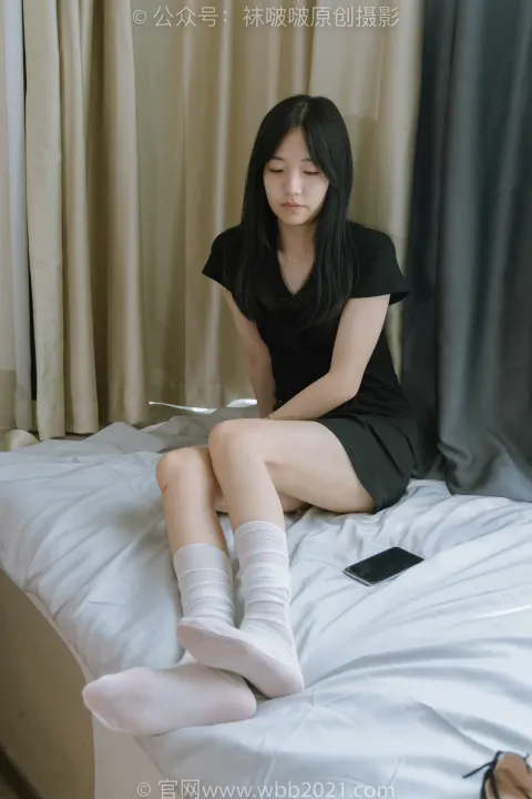 Araffe 坐在床上，手里拿着手机和笔记本电脑