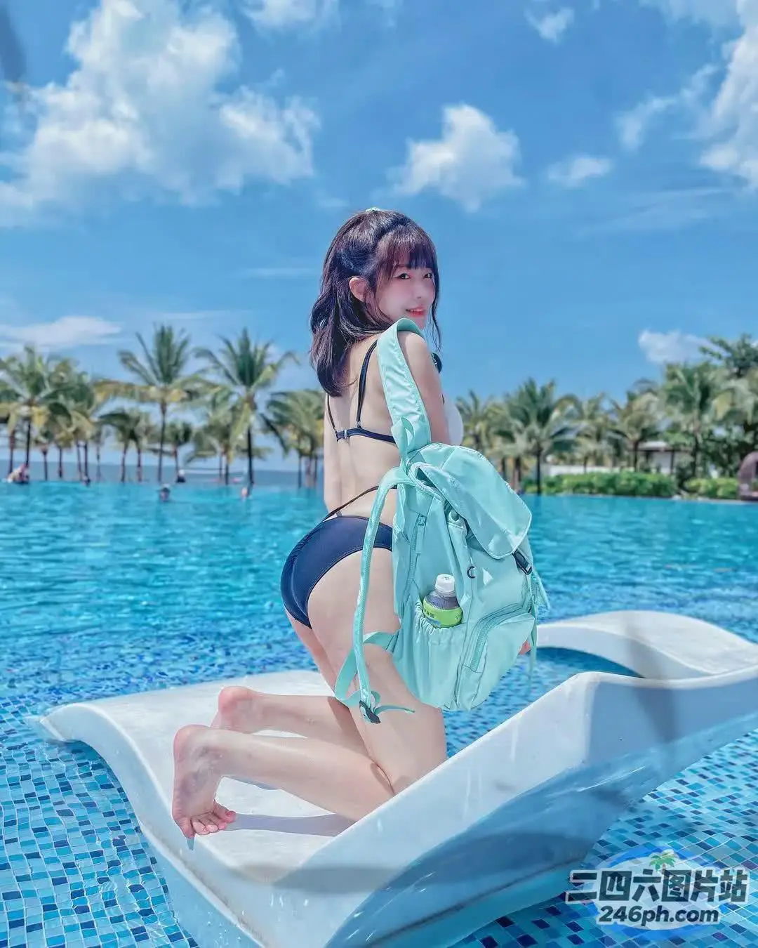 穿着比基尼的女人坐在游泳池里的白色船上