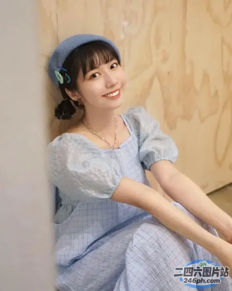 地板上坐着一个穿着蓝色连衣裙的女人