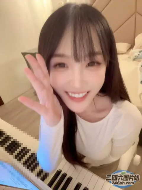 坐在钢琴前微笑的 arafed 亚洲妇女