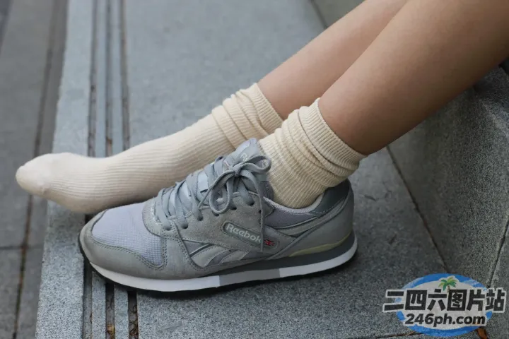 有人坐在台阶上，脚踩着一双运动鞋
