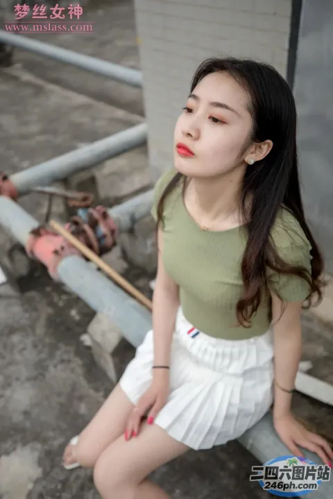 一位穿着绿色衬衫坐在长凳上的女人的特写