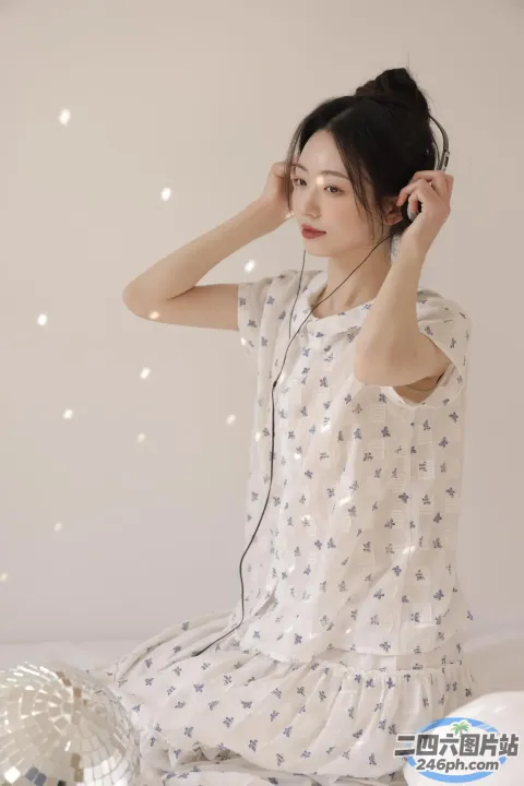 有个女人坐在床上，戴着耳机