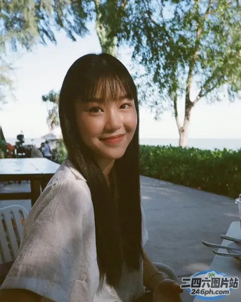 有个女人坐在一张桌子旁，桌上放着一盘食物