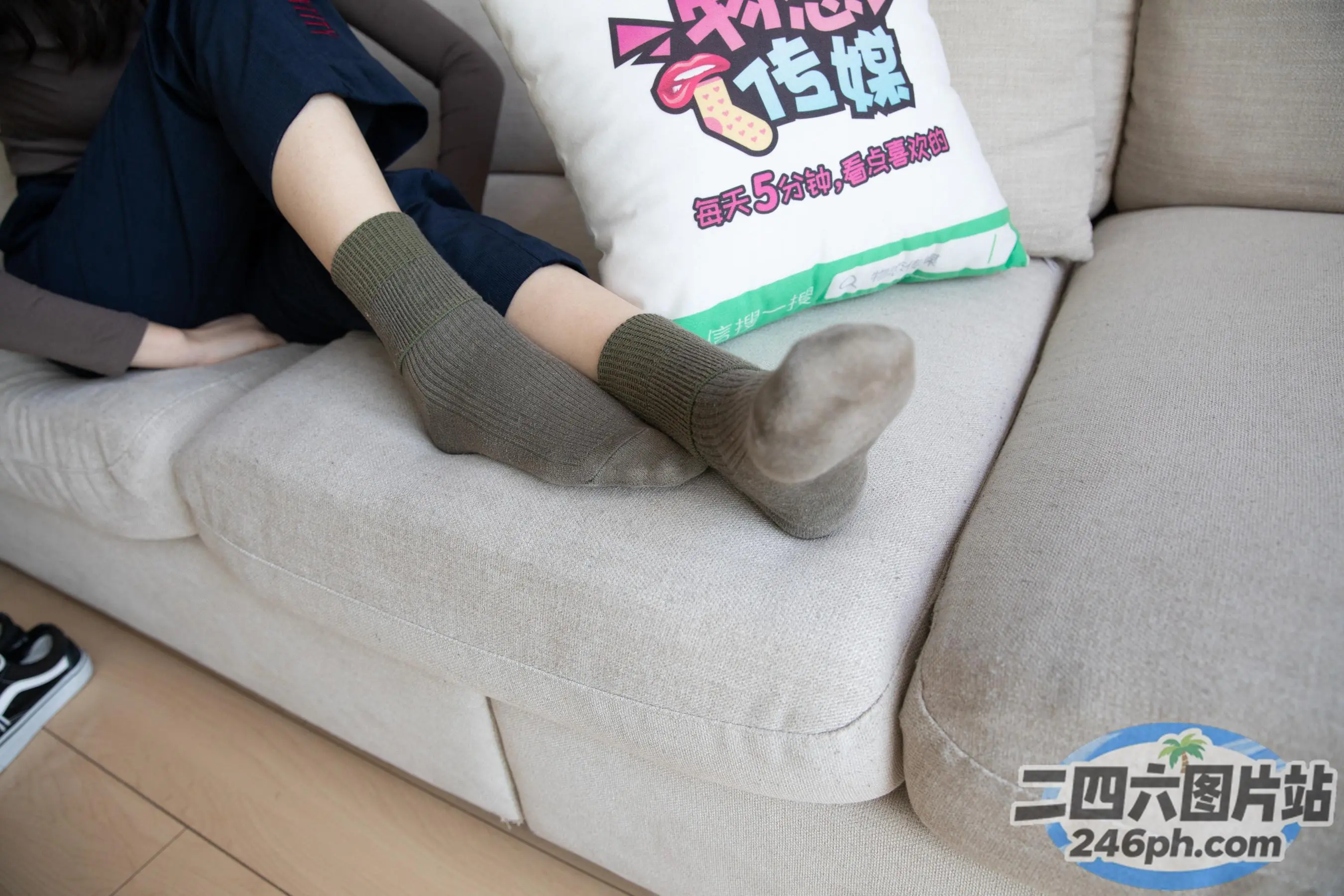 有一个女人坐在沙发上，上面有一个枕头