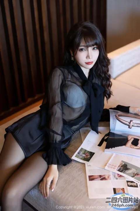 床上坐着一个女人，手里拿着一本杂志