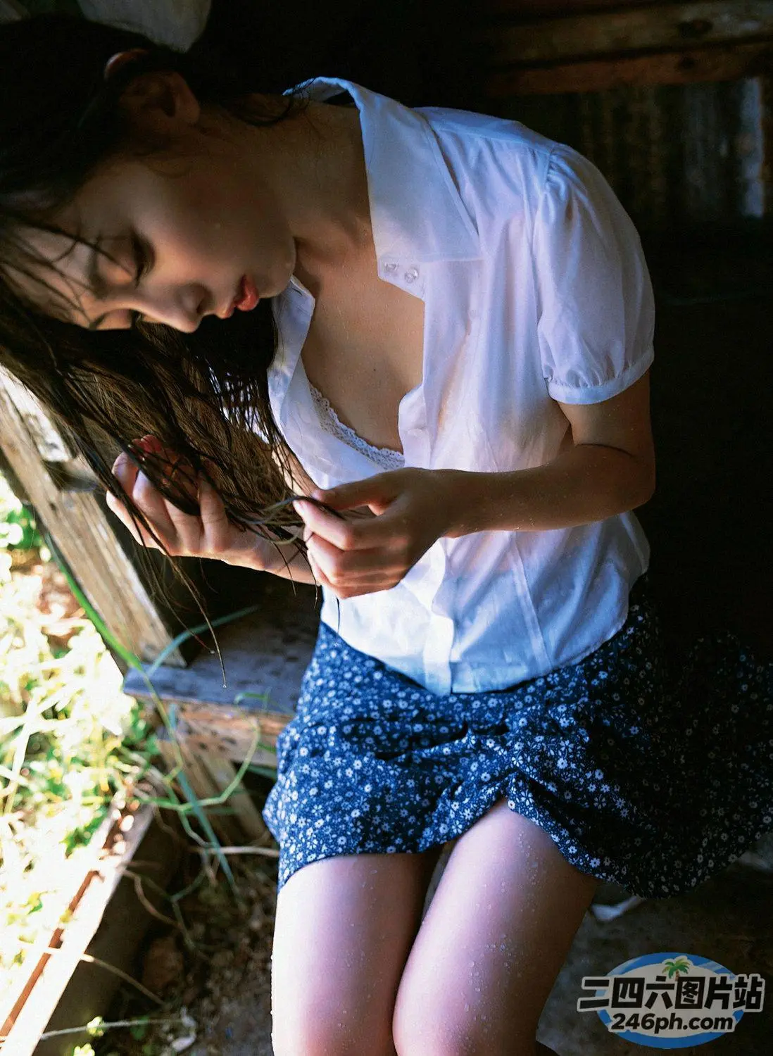 有个女人坐在长凳上，手里拿着手机