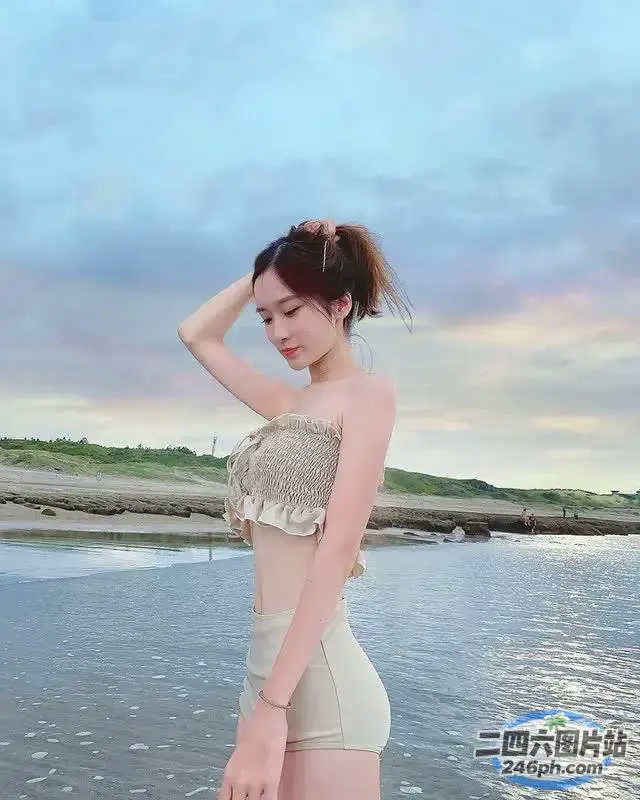一名身穿比基尼上衣的女子站在水中