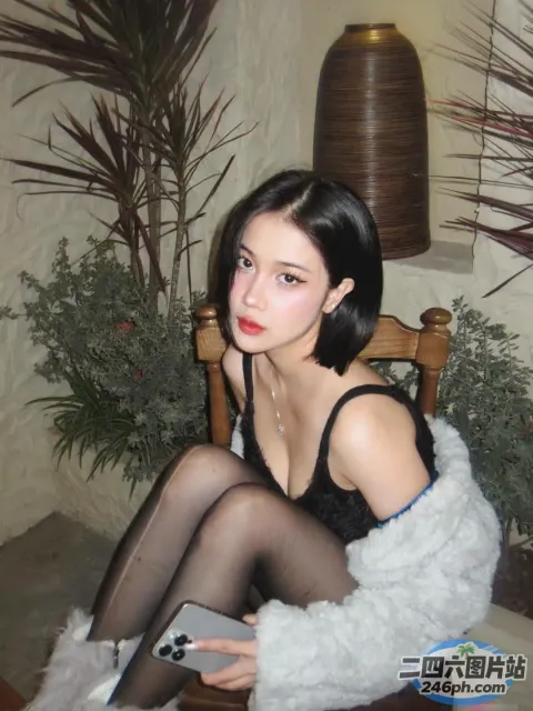 有一位女士坐在椅子上，手里拿着一台笔记本电脑